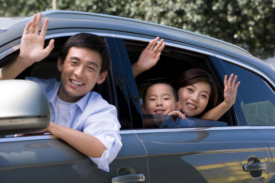 Family waves from their new car