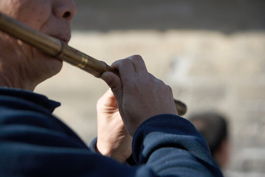 Close Up Of A Chinese Man Playing A Flute