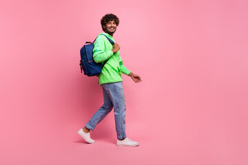 Full body length photo of steps young hipster student indian man wear rucksack behind going to study isolated on pink color background
