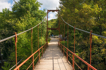A small cable suspension bridge crossing the River Una in Martin Brod in the Una National Park. Una-Sana Canton, Federation of Bosnia and Herzegovina. Early September