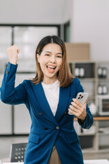 Business woman are excited business success with inspiration from their excellent financial results that are happy working in a modern office on a smartphone.