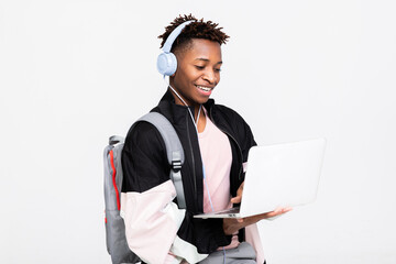 Cheerful afro american student guy holding laptop in hands watching movie films having fun enjoying...