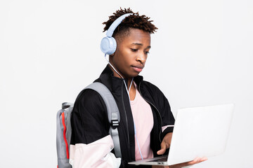Cheerful afro american student guy holding laptop in hands watching movie films having fun enjoying...
