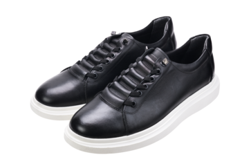 A pair of black sneakers with white soles isolated on a white background. 