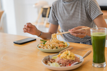 Asian Girl  eating Thai food in kitchen counter Home delivery food feeling happy 