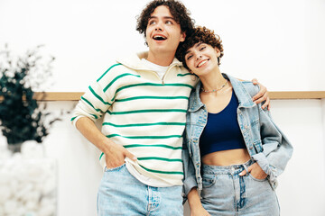 Smiling beautiful woman and her handsome boyfriend with curls hairstyle. Happy cheerful family having tender moments in white interior in studio.Pure cheerful models hugging. Embracing each other