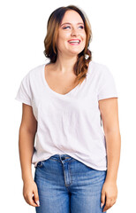 Fototapeta premium Young beautiful caucasian woman wearing casual white tshirt looking away to side with smile on face, natural expression. laughing confident.
