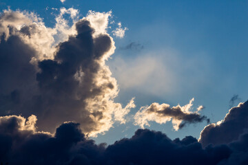 Thick dark blue clouds floating across the blue sky close up