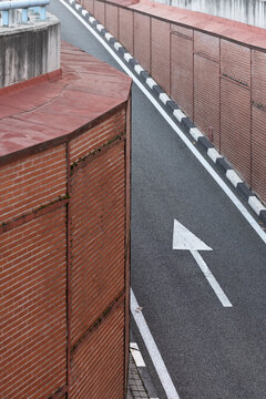 Top-down view of a directional arrow on street between walls, guiding the urban flow in confined cityscape