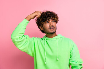 Portrait of thoughtful indian student wavy hair man scratch head looking empty space lectures schedule isolated on pink color background