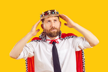 Ambitious self confident employee in king costume dreams of becoming business director. Bearded man...