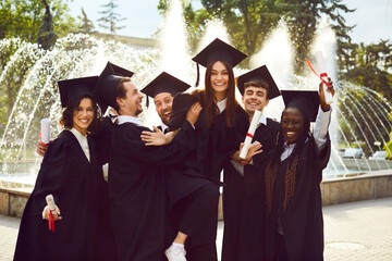 Portrait of a smiling happy multiracial international graduates students having fun standing in a...