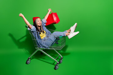 Full size photo of pretty young girl riding shopping cart hurry promo sales wear trendy jeans...