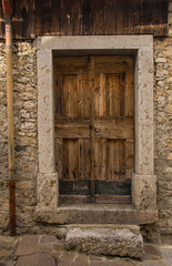 Fototapeta na wymiar A door in an historic residential building in the village of Trava in Lauco district, Udine Province, Friuli-Venezia Giulia, north east Italy