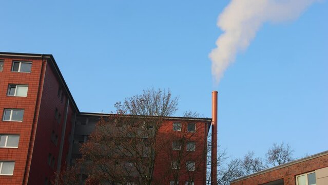 Rauchender Schornsteinschlot an einem Mehrfamilienhaus