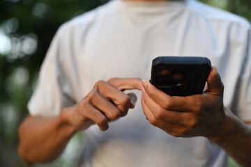 Cropped shot of sportsman using mobile phone after morning workout