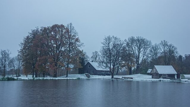 Timelapse shot of wooden cottage alongside a lake throughout various season. Weather changes. Seasonal concept.