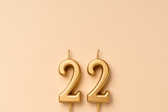 22 years celebration festive background made with golden candles in the form of number twenty-two. Universal holiday banner with copy space.