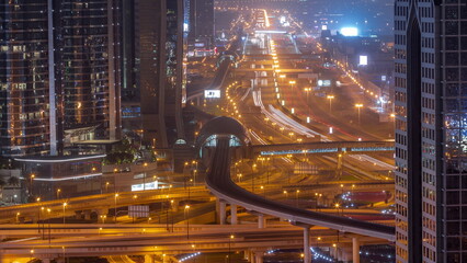 Busy Sheikh Zayed Road aerial all night timelapse, metro railway and modern skyscrapers around in...