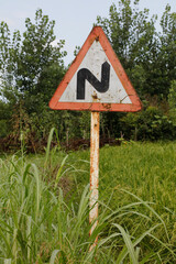 Turn right on a suburban road with a triangular road sign in the background.