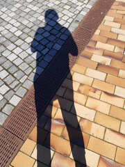 A Man`s Shadow on the Pavement