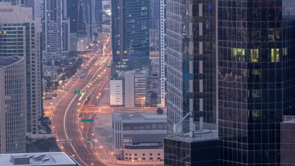 Aerial view from above to a busy road intersection in Dubai night to day timelapse.