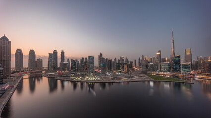 Fototapeta na wymiar Aerial panorama of Dubai Business Bay and Downtown with the various skyscrapers and towers day to night timelapse