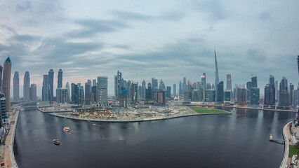 Fototapeta na wymiar Aerial view to Dubai Business Bay and Downtown with the various skyscrapers and towers day to night timelapse