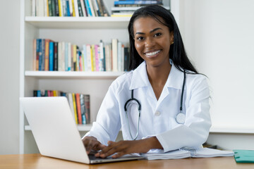Beautiful young latin american female doctor working at computer