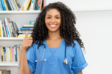 Motivated mexican nurse or medical student showing thumb up