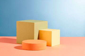 Three podiums in round and cube shaped are decorated against blue background. Pastel minimal wall scene collection. Modern platform for product display presentation