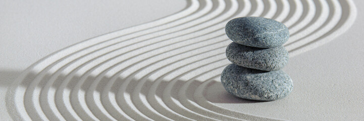 Japanese zen garden with stone in white textured sand