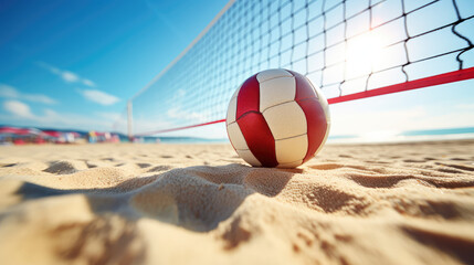 Close-up of white red beach volleyball on the sand of a sunny shore. Summer beach entertainment,...