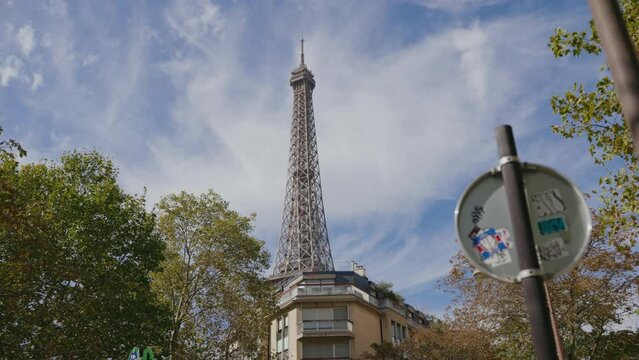 edificios de varias plantas en una calle de par&iacute;s y atr&aacute;s la torre Eiffel