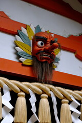 Japanese temple decoration with red mask and colorful leaves