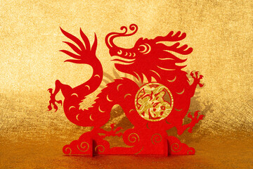 Chinese New Year of Dragon mascot paper cut on golden background English translation of the Chinese words are fortune and happy Chinese new year no logo no trademark