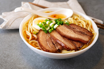 Asian ramen noodles soup with egg, pork and onion.