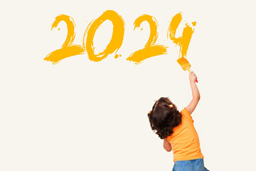 Cute little girl drawing new year 2024 with painting brush on wall background