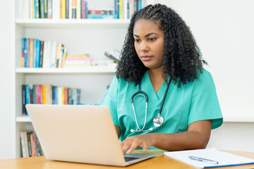 Serious latin american medical student or female nurse working at computer