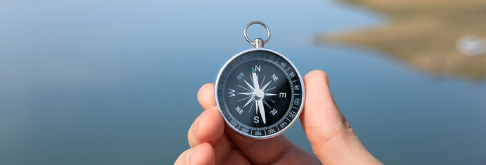 man holding compass in lake