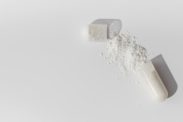 The white capsule was opened and a white powder poured out of it. Medicines, vitamins.Copy space