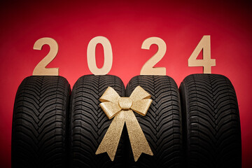 Car tires, new tyres, winter wheels isolated on christmas red background with text happy new year...