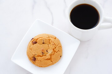 チョコレートがたっぷり入ったチョコチップクッキーとコーヒーでおやつの時間
