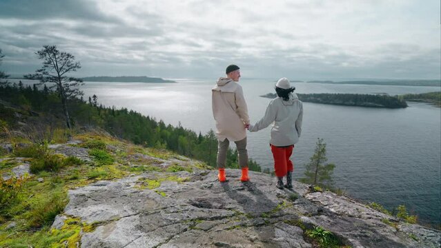 Happy Loving Man And Woman Standing At Top Of Mount And Admiring Landscape With Fjord, Back View
