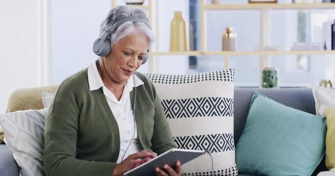 Senior woman, headphones and music on tablet, smile and laughing for funny podcast. Elderly person, couch and streaming radio and song or audio to relax in retirement, technology and internet at home
