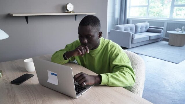 Young happy smiling afroamerican man working with modern laptop, technology and lifestyle young people concept