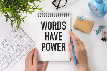 White paper with text Words have power lying on the keyboard