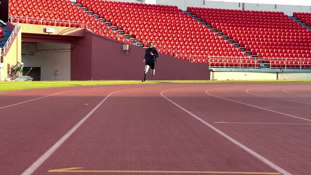 Asian para-athletes with prosthetic blades sprint on a running track at stadium.