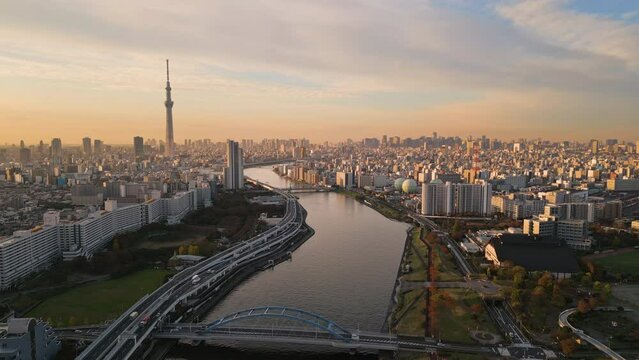 tokyo city aerial view drone of skytree tower asakusa district at sunrise,flying over sumida river modern building and skyscrapers skyline in the background at dawn