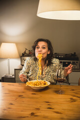 Gorgeous woman eating a plate of Tagliatelle al Ragù Bolognese in a cozy dining room; this...